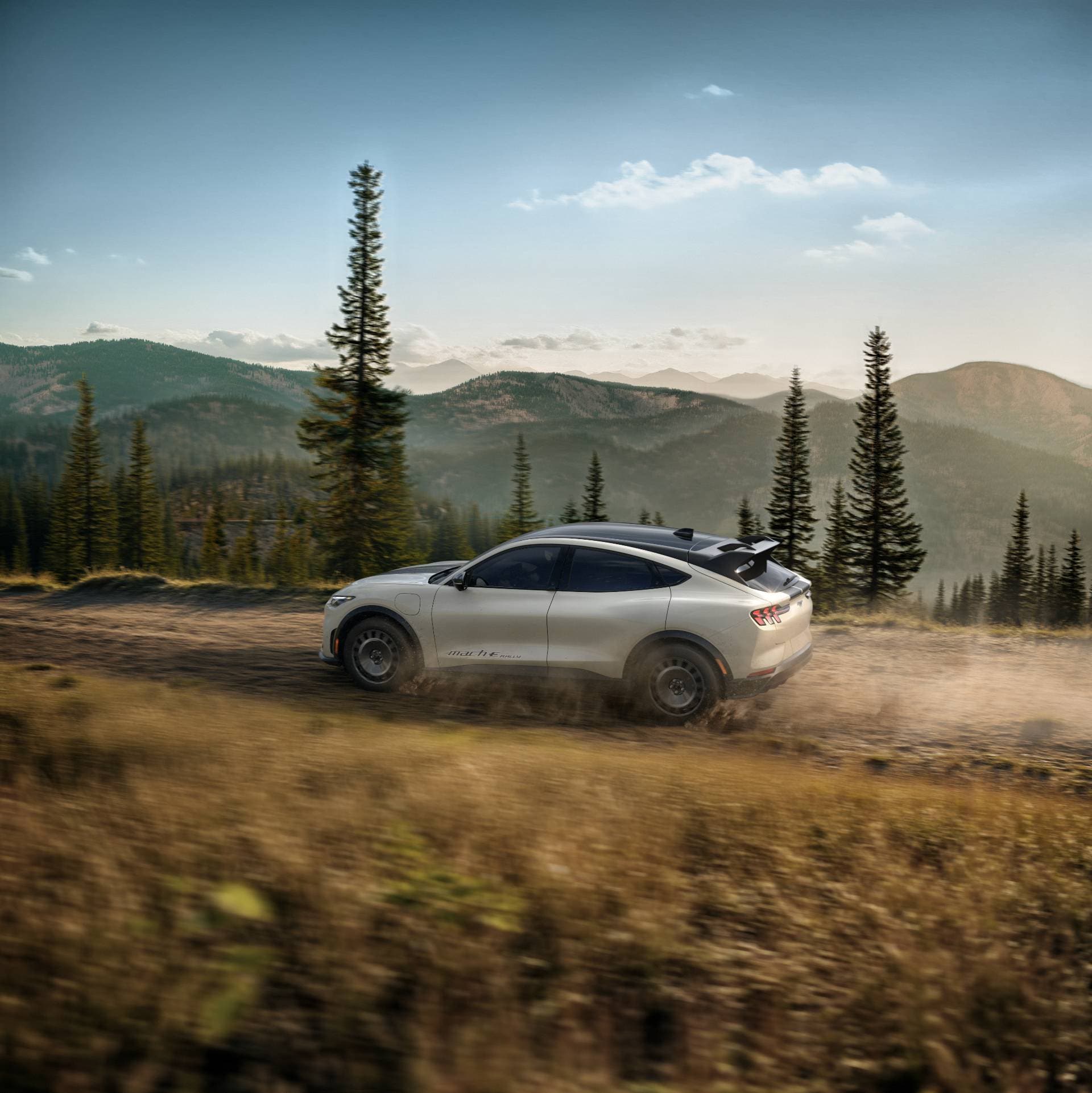 A Ford Mach-e driving on a dirt road.